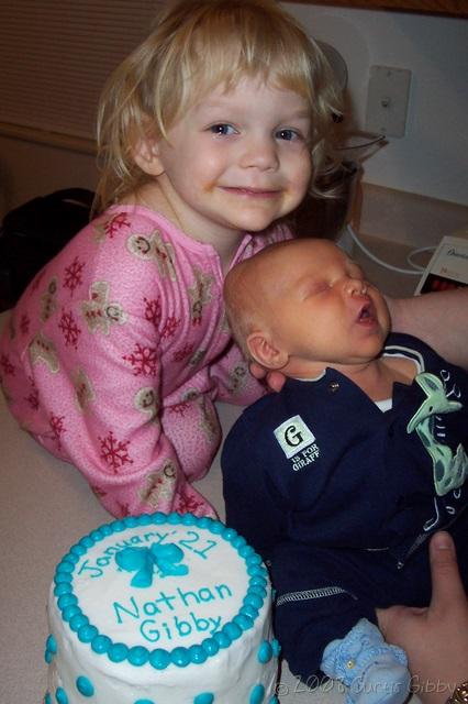 Nathan y Audrey posan con una torta de cumpleaños
