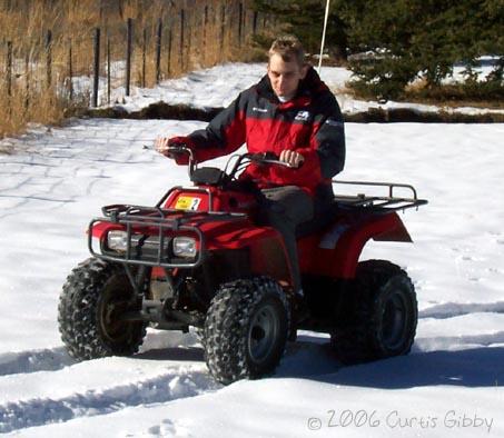 Curtis riding a 4-wheeler in the snow