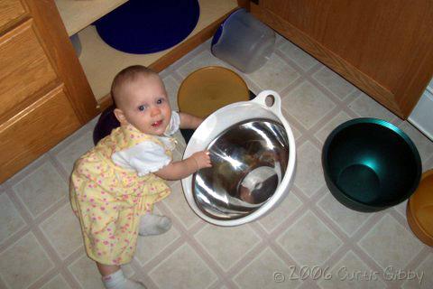 Audrey plays in the bowl cupboard