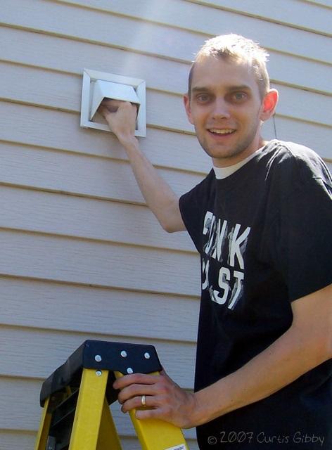 Curtis removes a bird's nest from the dryer vent