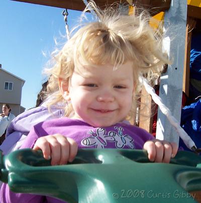 Audrey swinging on our neighbor's swing-set